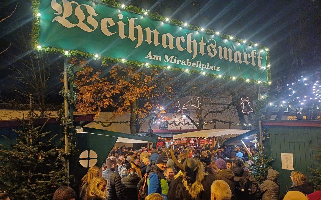 傍晚亮灯的米拉贝尔广场圣诞市集入口，离圣安德烈教堂和 Salzburger Advent 只有几分钟步行路程