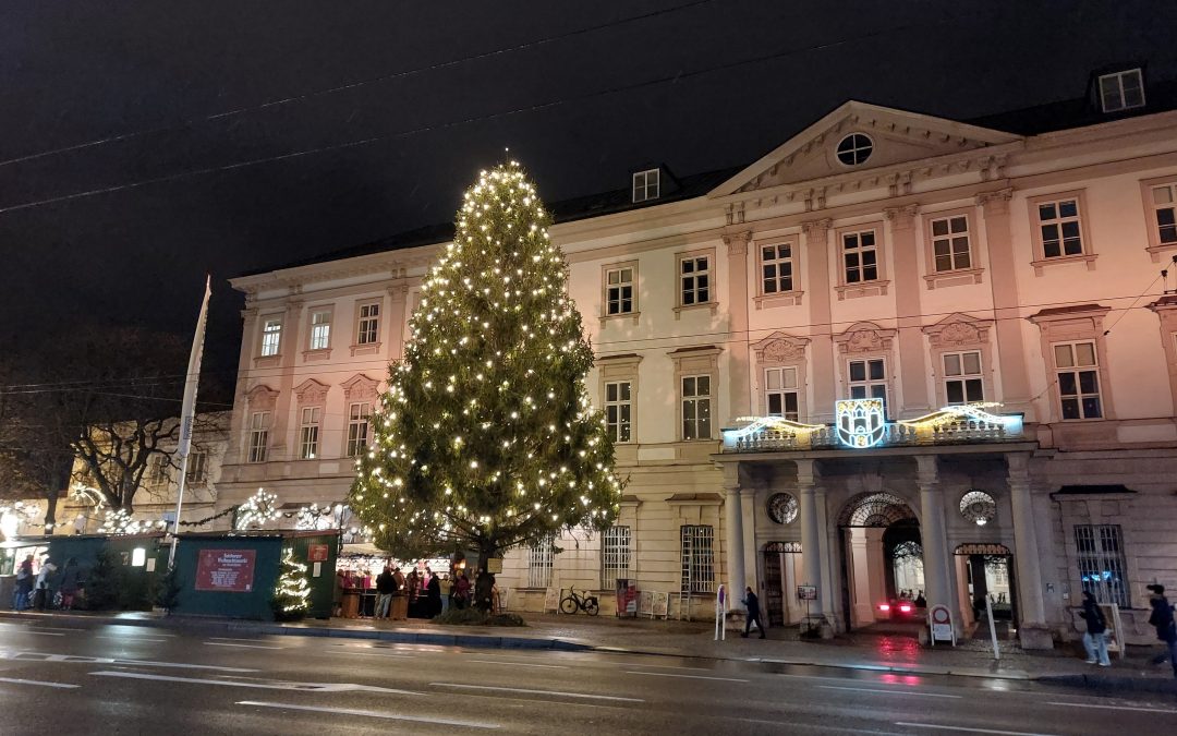 Beleuchteter Christbaum vor Schloss Mirabell am Abend, wo im Advent die Bläser der Adventmusik spielen