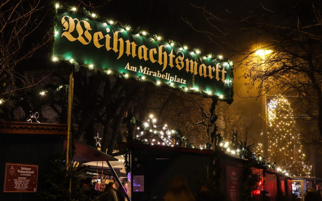 Beleuchteter Eingangsbogen des Weihnachtsmarkts am Mirabellplatz in Salzburg am Abend