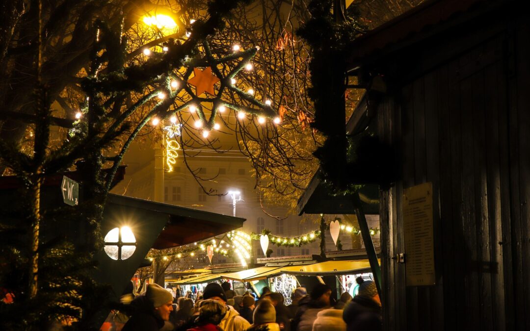 Leuchtender Stern über den Hütten am Weihnachtsmarkt Mirabellplatz am Abend, Start und Ziel für Salzburg an einem Tag im Advent