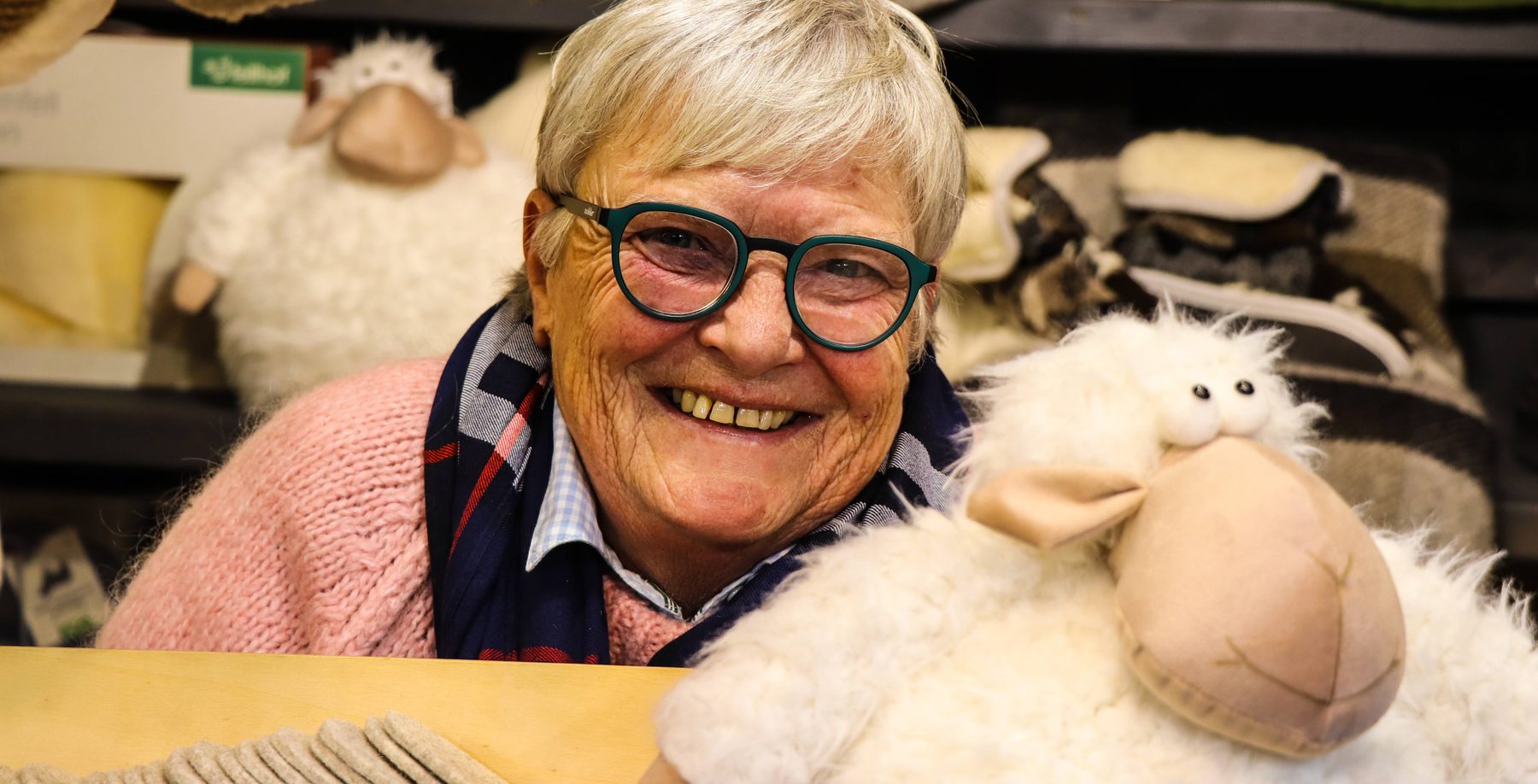Lächelnde Standlerin mit Plüschschaf in der Woll- und Fellhütte von Alexandra Wirnsberger am Weihnachtsmarkt Mirabellplatz