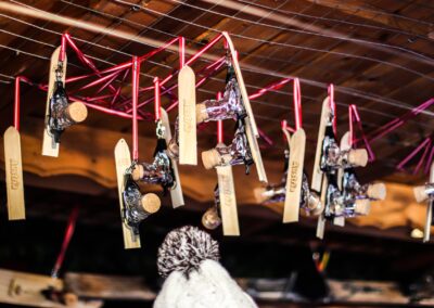 Mini-Ski mit Skischuh-Schnapsgläsern hängen an der Decke der Hütte von Apres Allstars
