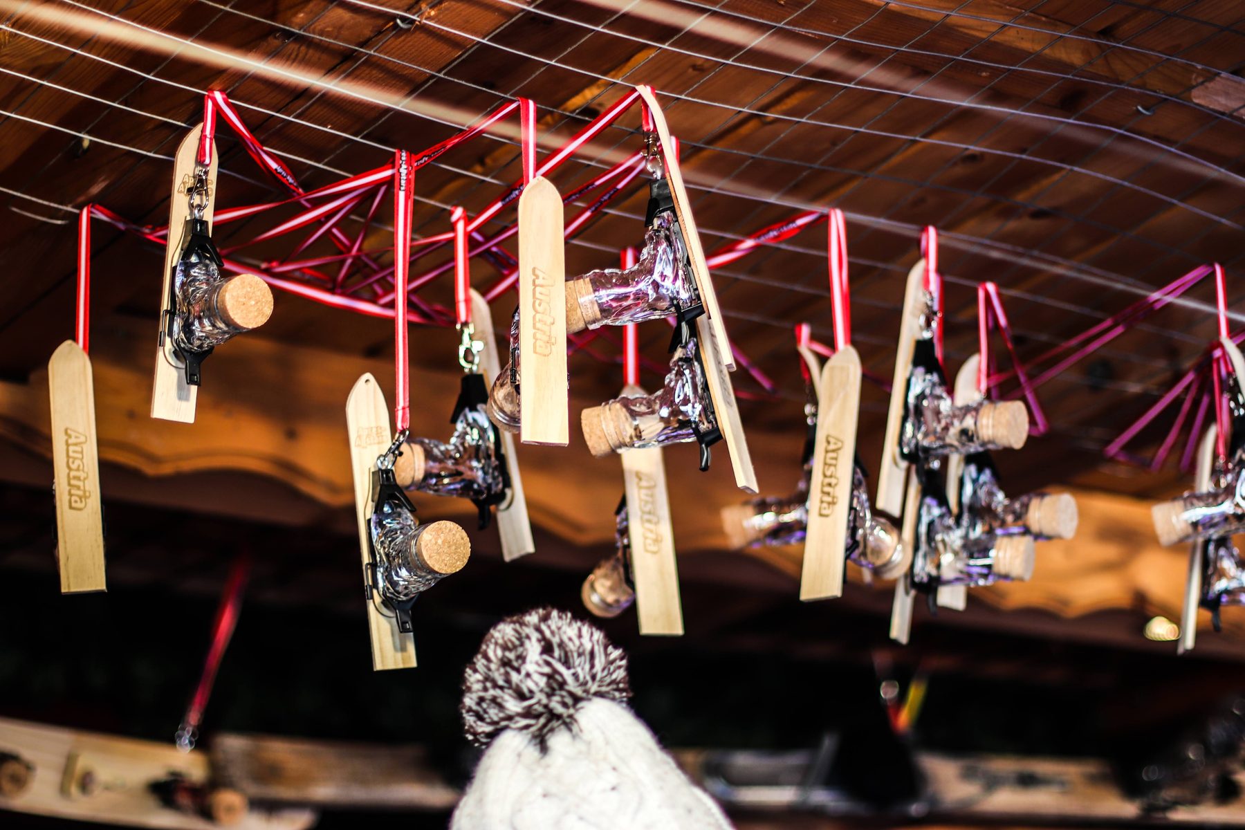 Mini-Ski mit Skischuh-Schnapsgläsern hängen an der Decke der Hütte von Apres Allstars