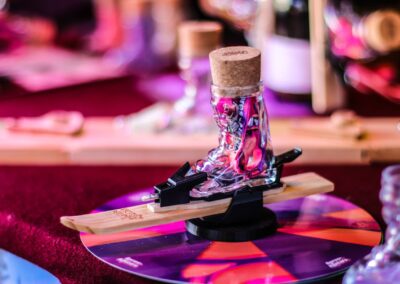Schnapsglas in Skischuhform mit Bindung auf einem kleinen Ski bei Apres Allstars