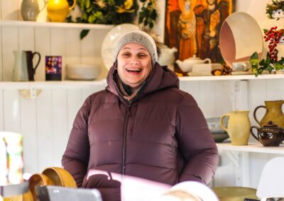 Lachende Standlerin in der Keramikhütte von La Poterie de Taizé am Weihnachtsmarkt Mirabellplatz