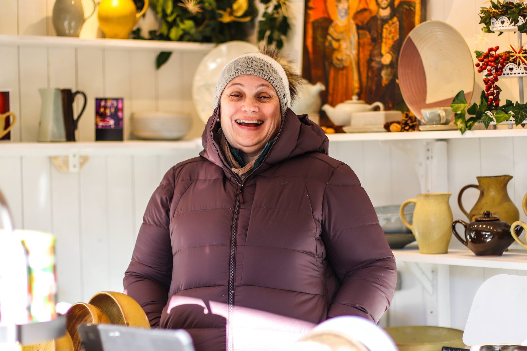 Lachende Standlerin in der Keramikhütte von La Poterie de Taizé am Weihnachtsmarkt Mirabellplatz