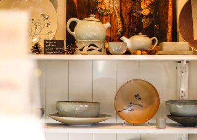 Teekannen, Schalen und bemalte Teller vor einer Ikone bei La Poterie de Taizé