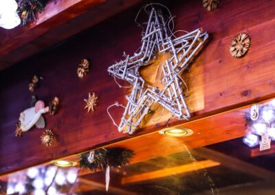 Holzwand mit Drahtstern, Holzsternen und Lichtern in der Hütte von Ludwig Glier
