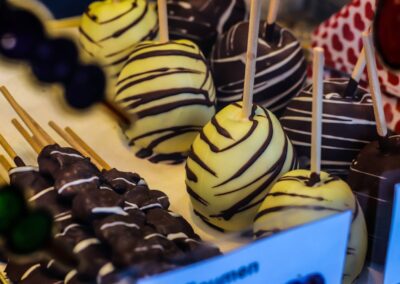 Äpfel mit weißer Schokolade und dunklen Streifen am Stiel in der Auslage von Ludwig Glier