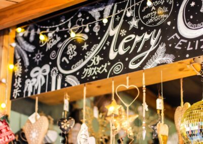 Kreidetafel „Merry Christmas“ und hängende Weihnachtsdeko an der Hütte von Tanja Konrad